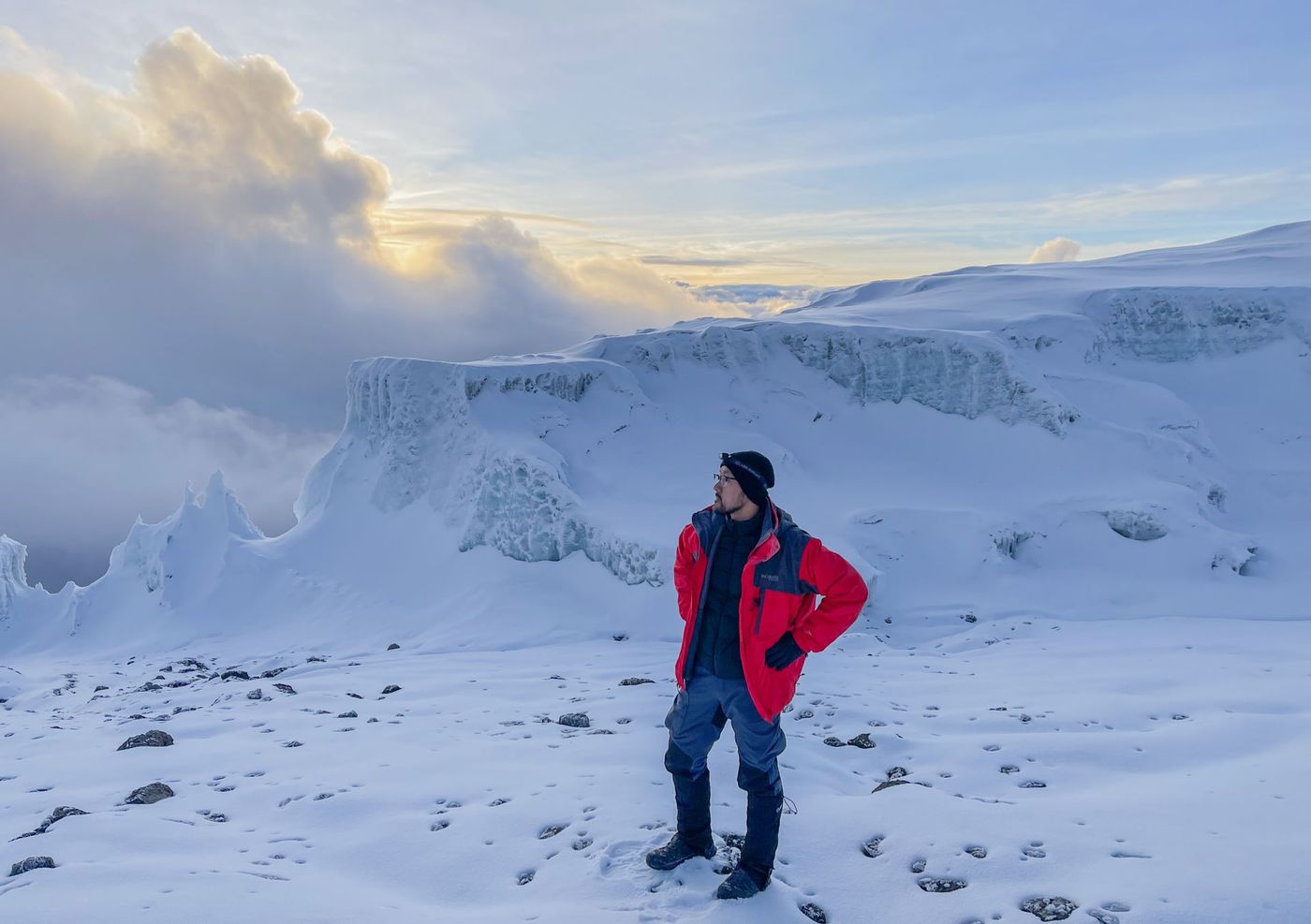Climber beside a Kilimanjaro summit glacier at sunrise